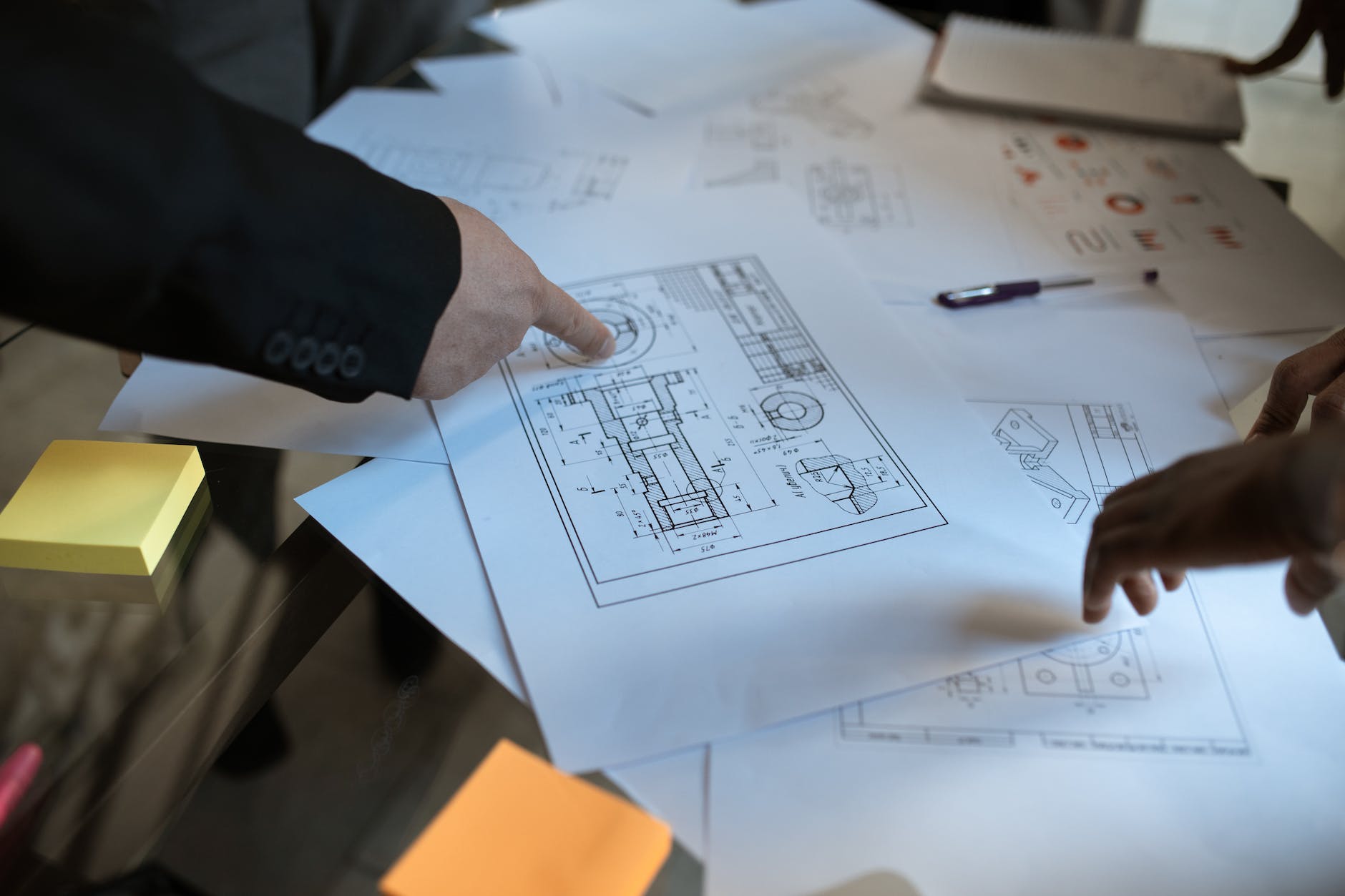 person pointing on a project plan in blueprint